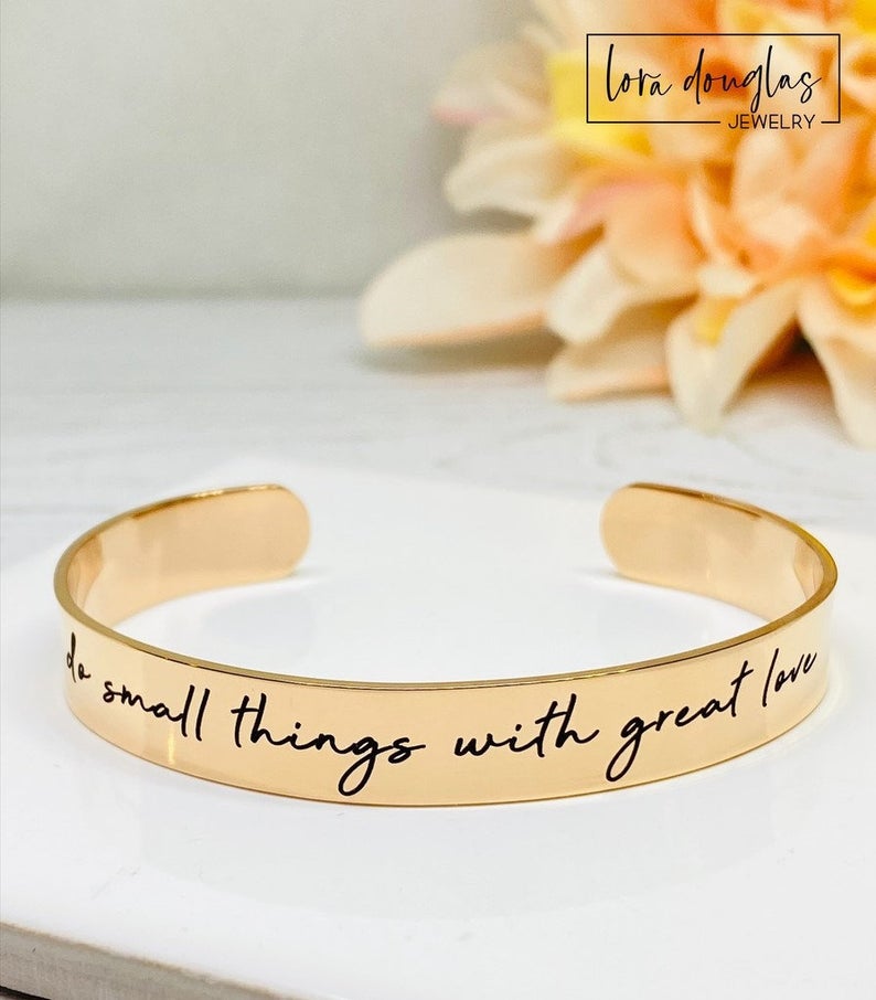 rose gold stainless steel cuff bracelet with an engraved message 'Do small things with great love'.