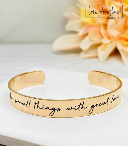rose gold stainless steel cuff bracelet with an engraved message 'Do small things with great love'.