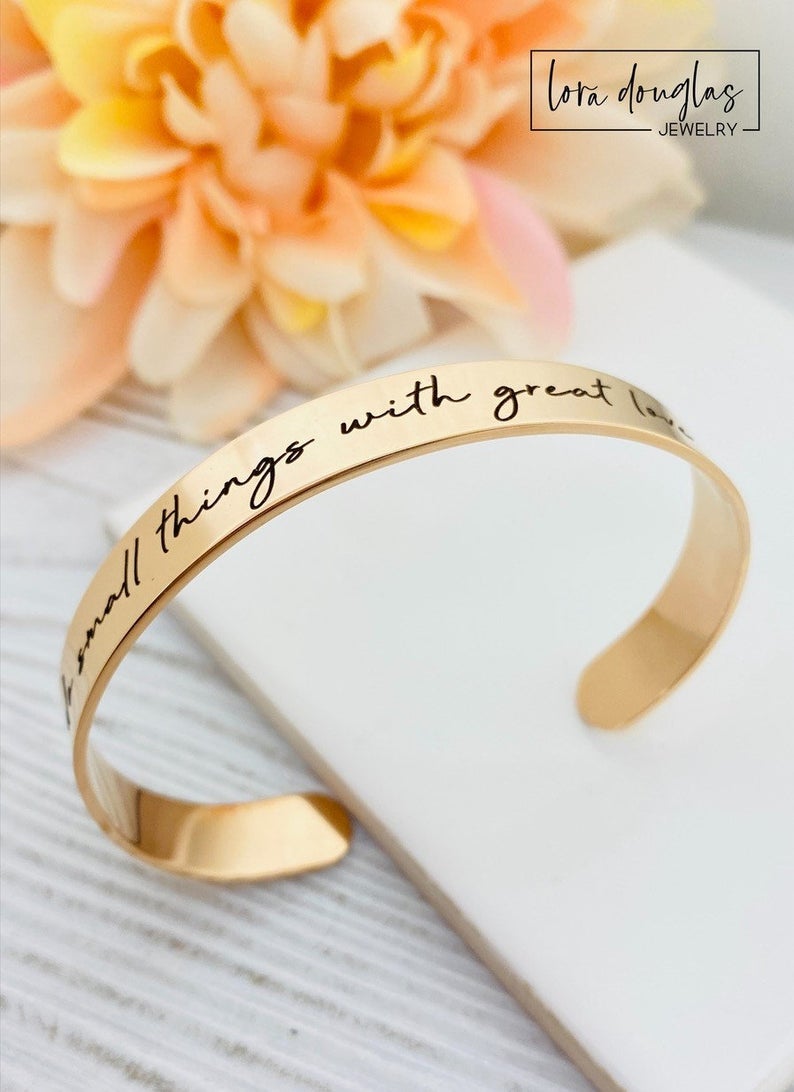 rose gold stainless steel cuff bracelet with an engraved message 'Do small things with great love'.