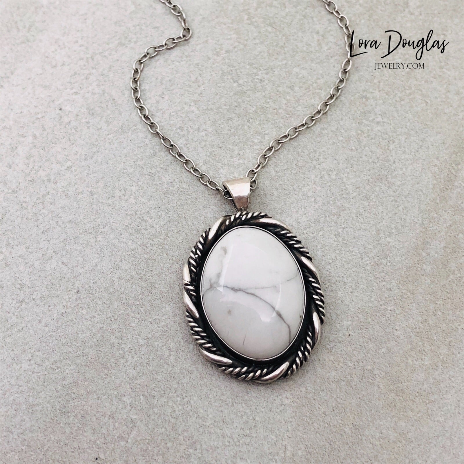 A sterling silver pendant necklace with a white howlite stone set in a silver setting, attached to an 18-inch sterling silver chain with a C clasp.
