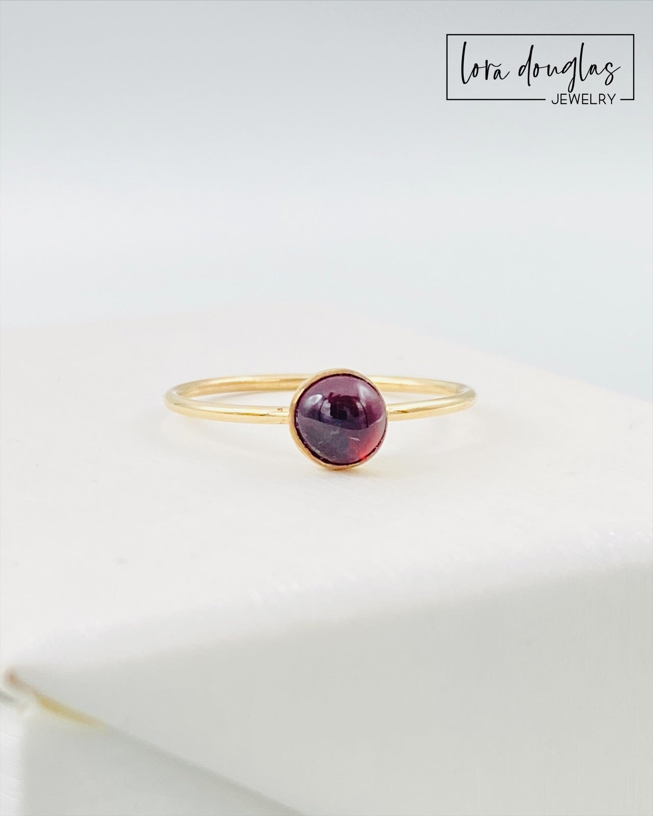Gold-filled garnet solitaire ring, size 6, with a flat band and a polished finish, displayed on a plain background.