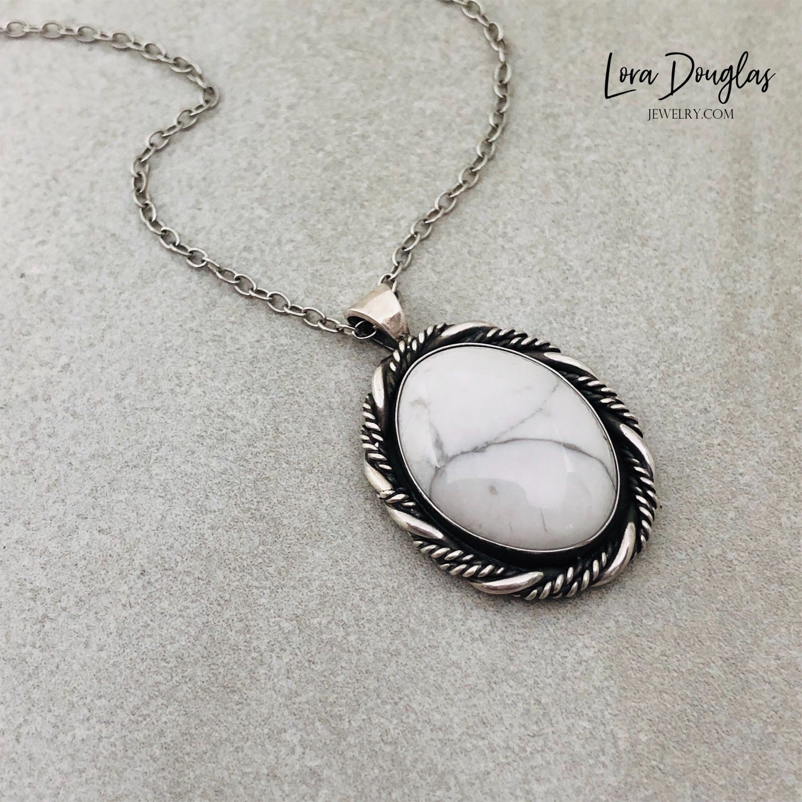 A sterling silver pendant necklace with a white howlite stone set in a silver setting, attached to an 18-inch sterling silver chain with a C clasp.