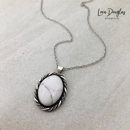 A sterling silver pendant necklace with a white howlite stone set in a silver setting, attached to an 18-inch sterling silver chain with a C clasp.