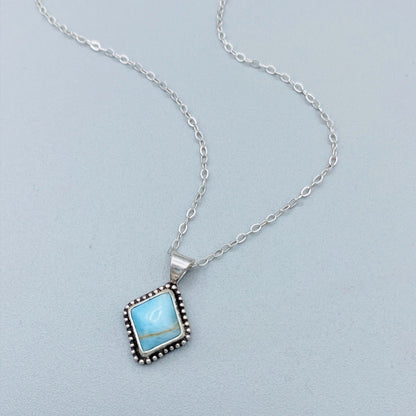 A sterling silver pendant necklace with a turquoise stone and a silver chain.