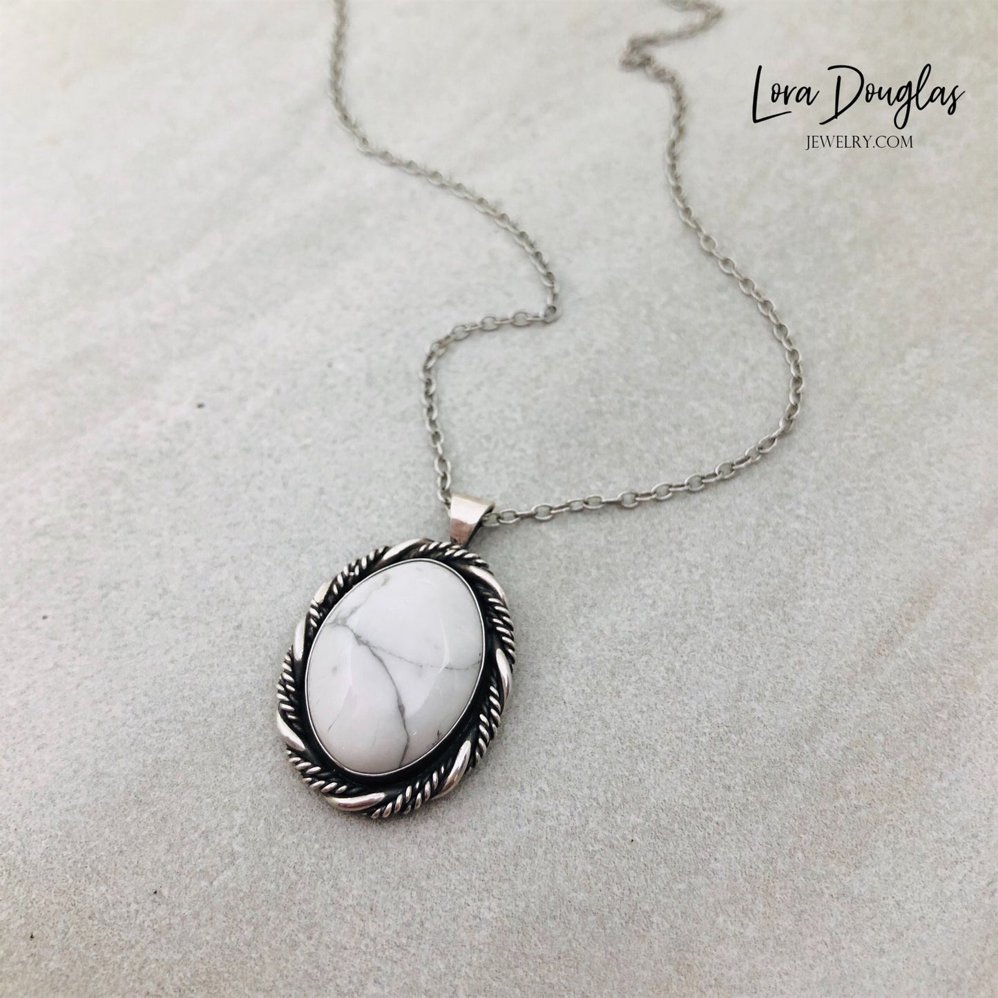 A sterling silver pendant necklace with a white howlite stone set in a silver setting, attached to an 18-inch sterling silver chain with a C clasp.