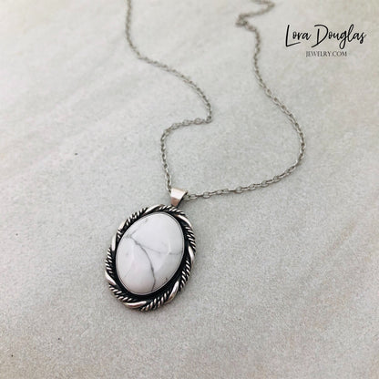 A sterling silver pendant necklace with a white howlite stone set in a silver setting, attached to an 18-inch sterling silver chain with a C clasp.