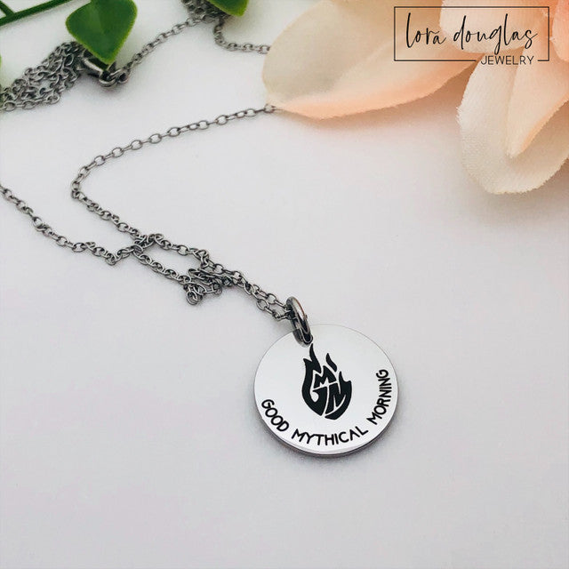 Three custom jewelry charms with engraved logos on a disc-shaped pendant, attached to different types of jewelry including a necklace and a bracelet, with the option to engrave your logo.