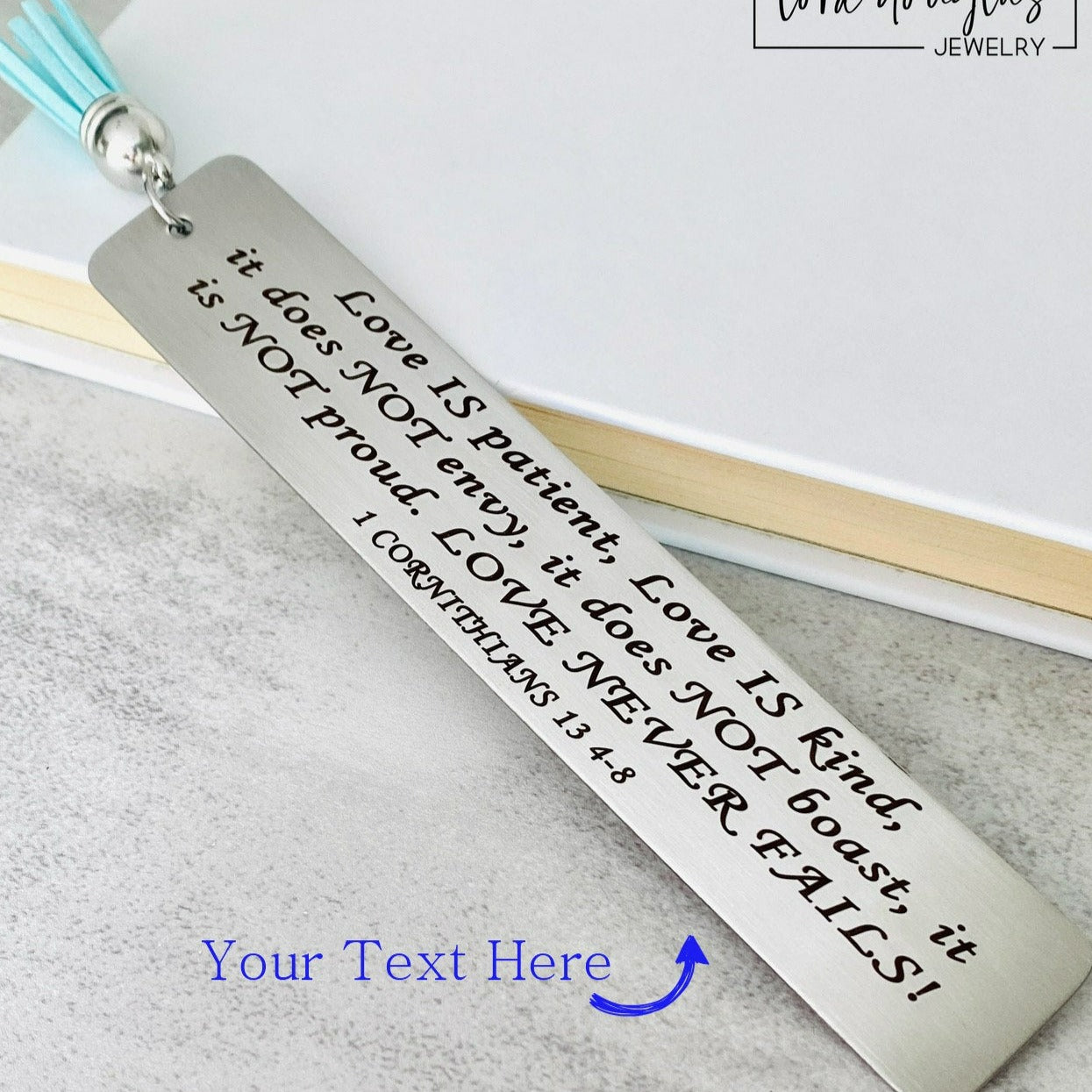 personalized bible verse bookmark engraved with custom scripture on stainless steel metal bookmark with leather tassel, christian bookmark gift displayed inside open Bible with permanent laser engraved verse detail
