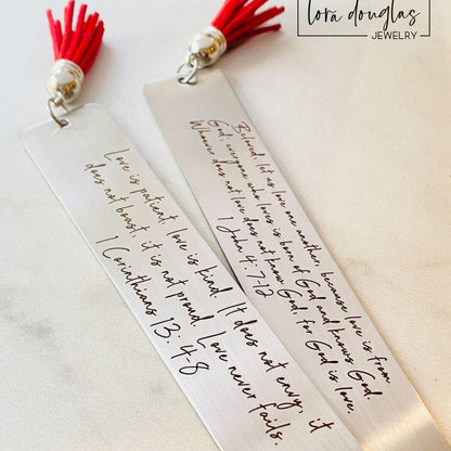 personalized bible verse bookmark featuring engraved scripture and leather tassel displayed beside Bible pages, stainless steel christian bookmark gift with permanent dark laser engraving and brushed silver finish