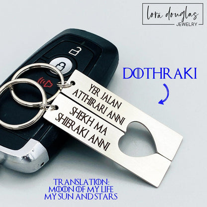 Two silver stainless steel keychains with Dothraki engraving, presented on a car key. One keychain reads 'Yer Jalan Atthirari Anni' and the other reads 'Shekh Ma Shieraki Anni', with optional personalization. Game of Thrones Gift